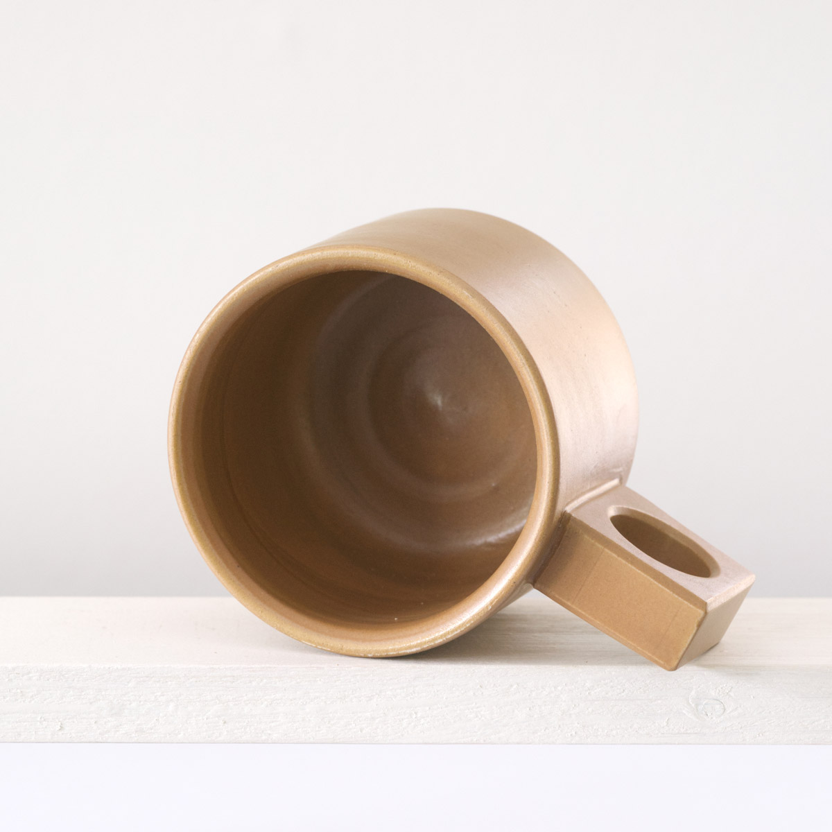 Sicht in eine kleine Tasse mit einer matten, karamellfarbenen Glasur