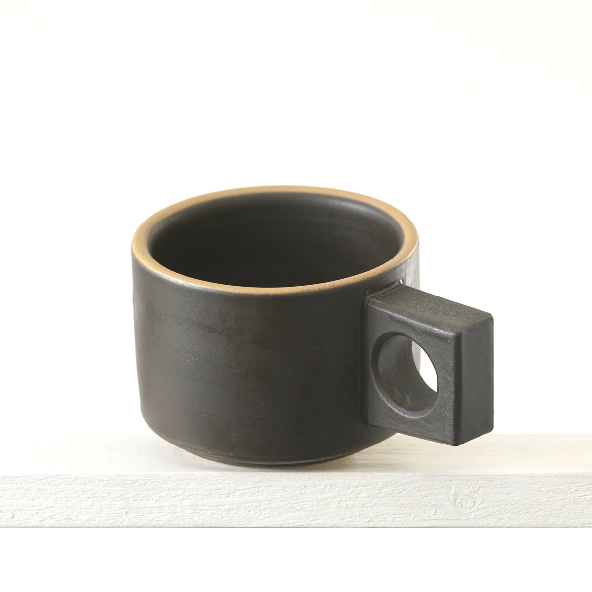 Schräge Ausicht auf eine kleinen Tasse mit einer matten, dunklen mokkafarbenenfarbenen Glasur