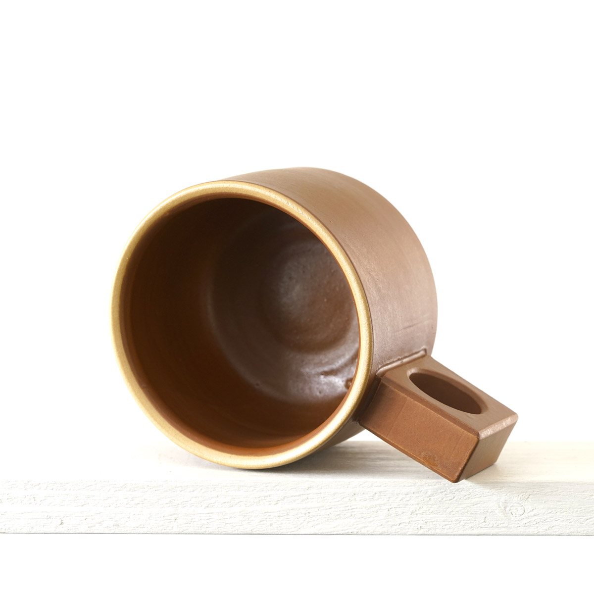 Sicht in eine kleinen Tasse mit einer matten, zimtfarbenen Glasur 