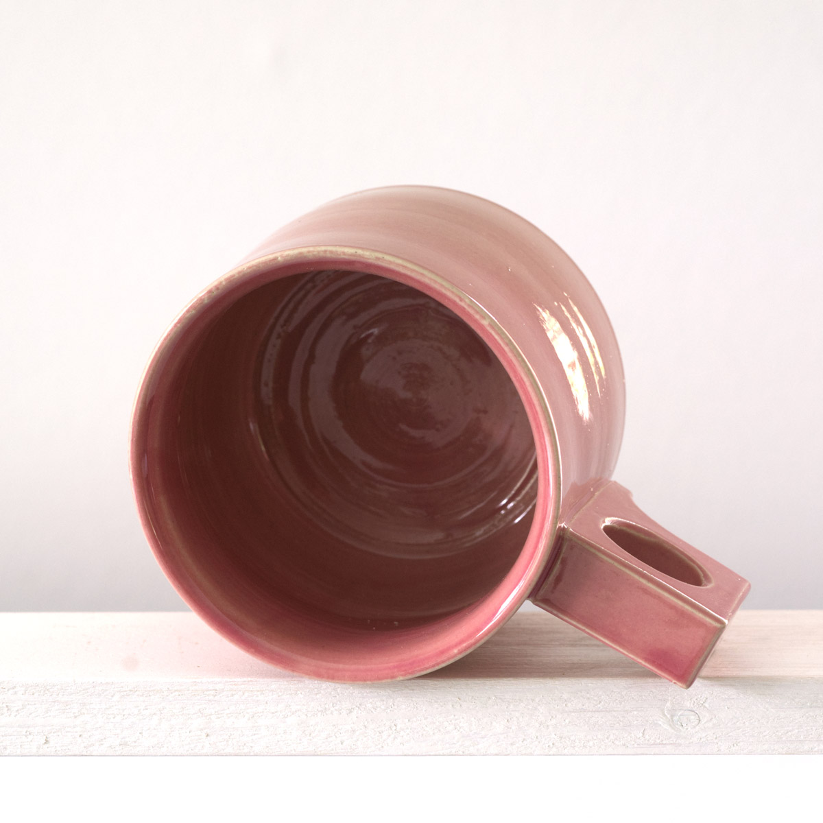 Sicht in eine große Tasse mit einer glänzenden, altrosefarbenen Glasurn