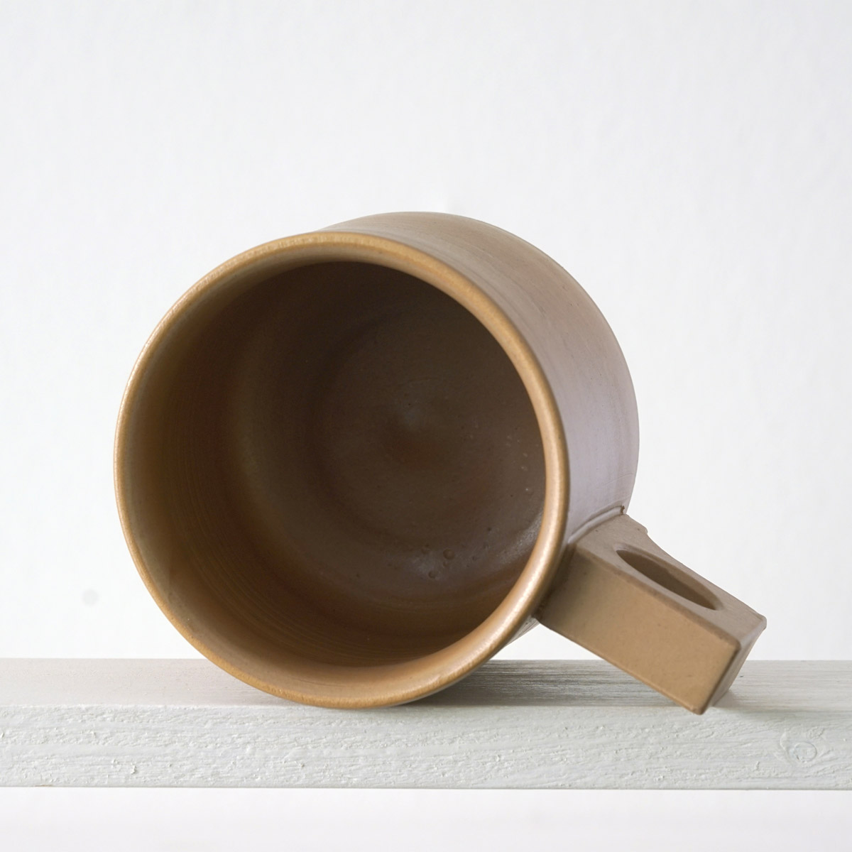 Sicht in eine große Tasse mit einer matten, karamellfarbenen Glasurn eine