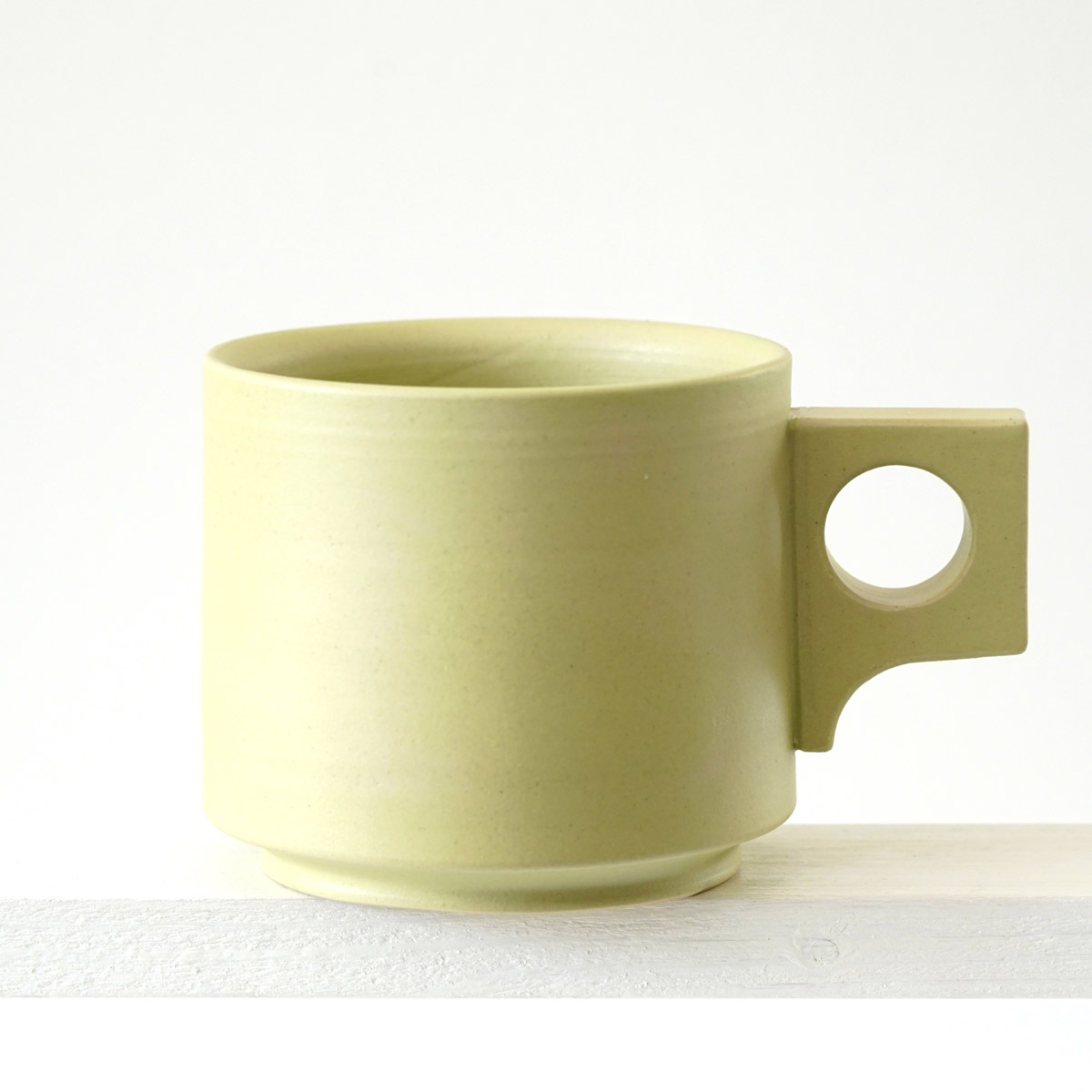 Seitenansicht einer große Tasse mit einer matten, limonenfarbenen Glasur