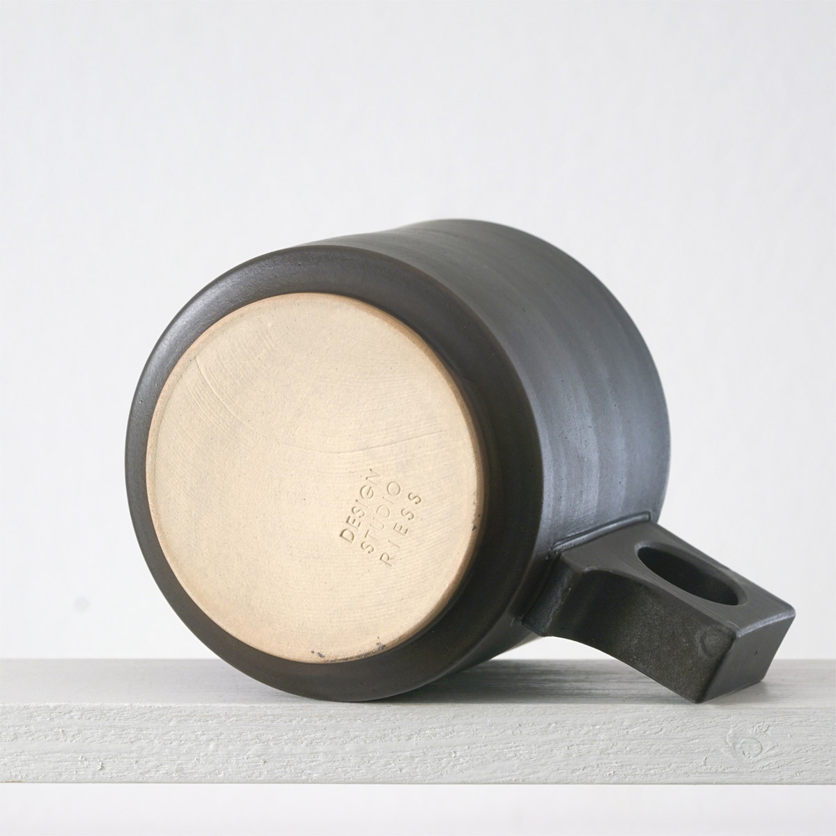 Unteransicht einer große Tasse mit einerur matten, dunklen mokkafarbenen Glasur